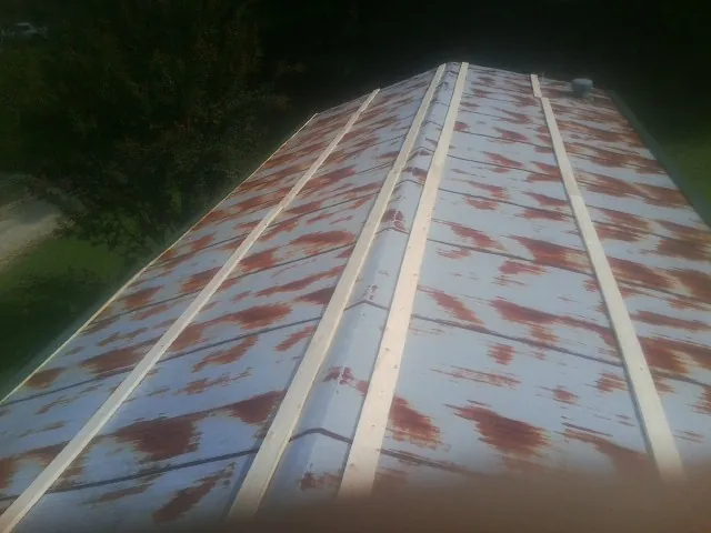 Rusted metal roof panels with new wood purlins before replacement — Storm Damage Roof Repair in Cannon Falls by Roofing Brothers