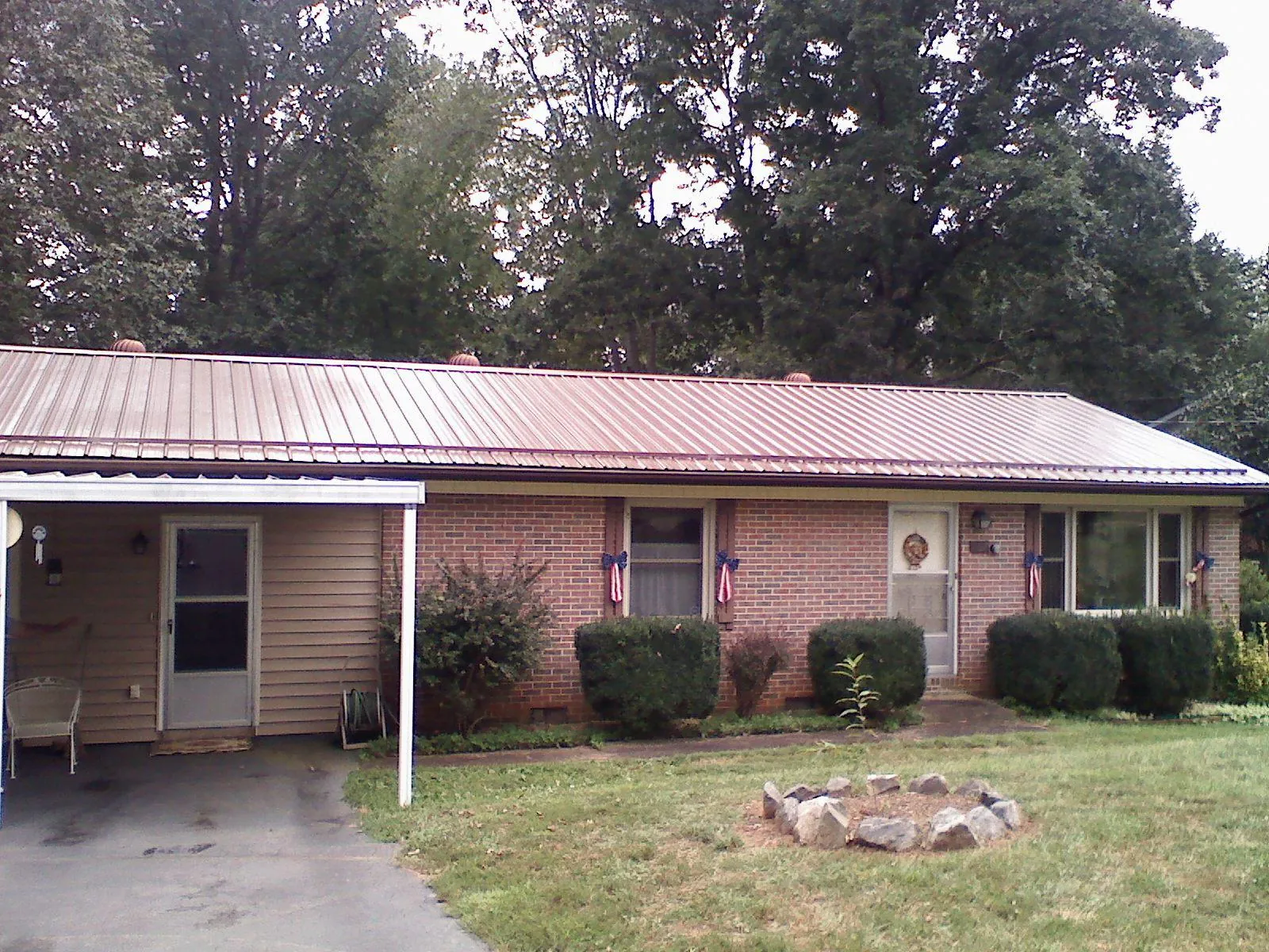 Bronze metal roof and carport on a brick ranch home — Roof Repair work by our crew in Cannon Falls